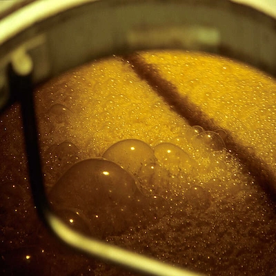 Beet mash undergoing slow enzymatic fermentation in traditional vessels
